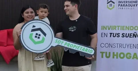 Familia joven con el cartel SOY PROPIETARIO